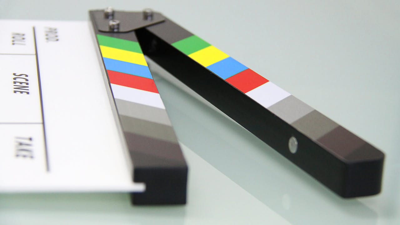 get-in-touch Colorful clapper board on a white surface, used in filmmaking. Ideal for entertainment and movie themes.